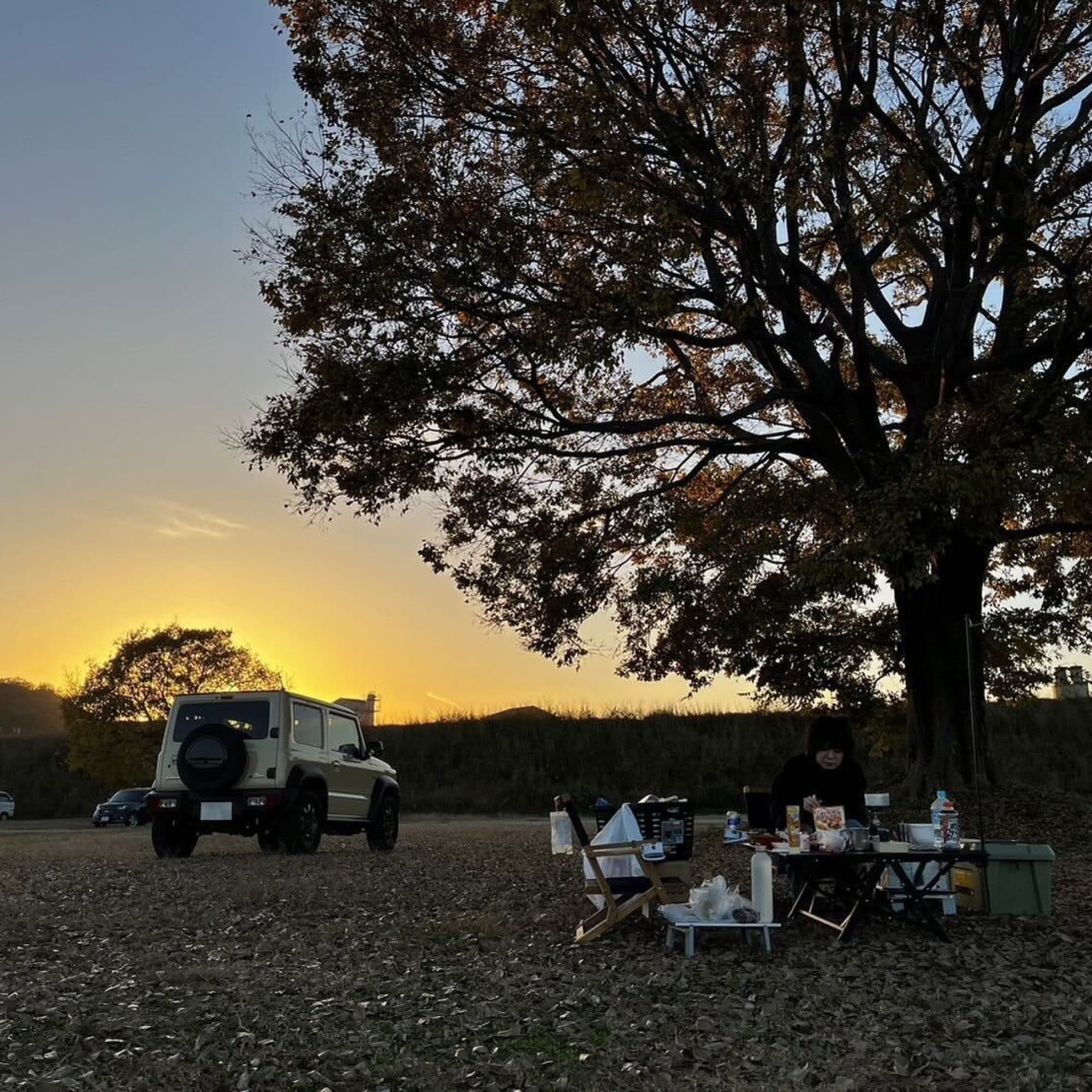景色が綺麗な河川敷で、夕陽をバックにキャンプ